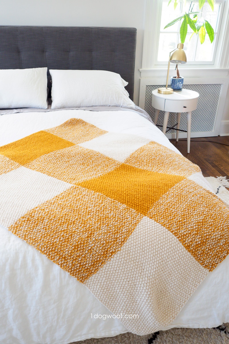gold and cream buffalo plaid throw on bed