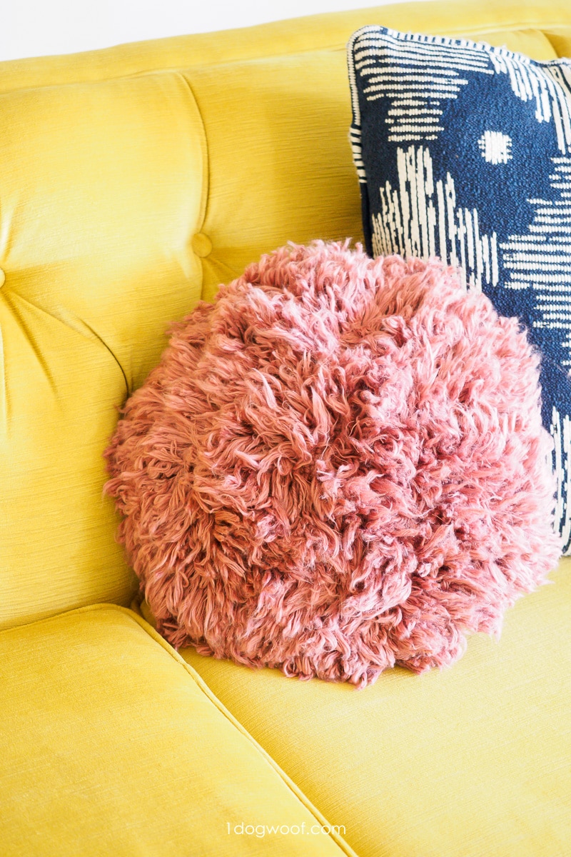 pink shag crochet pillow on yellow couch