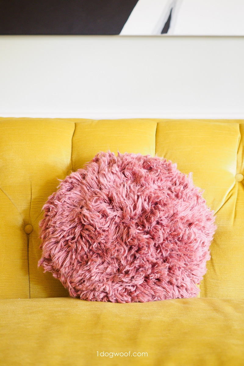 pink shag throw pillow on yellow couch