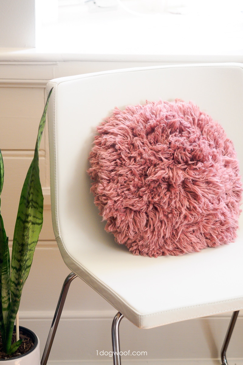 pink shag accent pillow on white chair